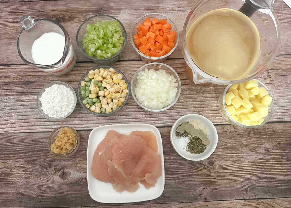 Ingredients for the recipe sit in glass bowls on a wooden background. 