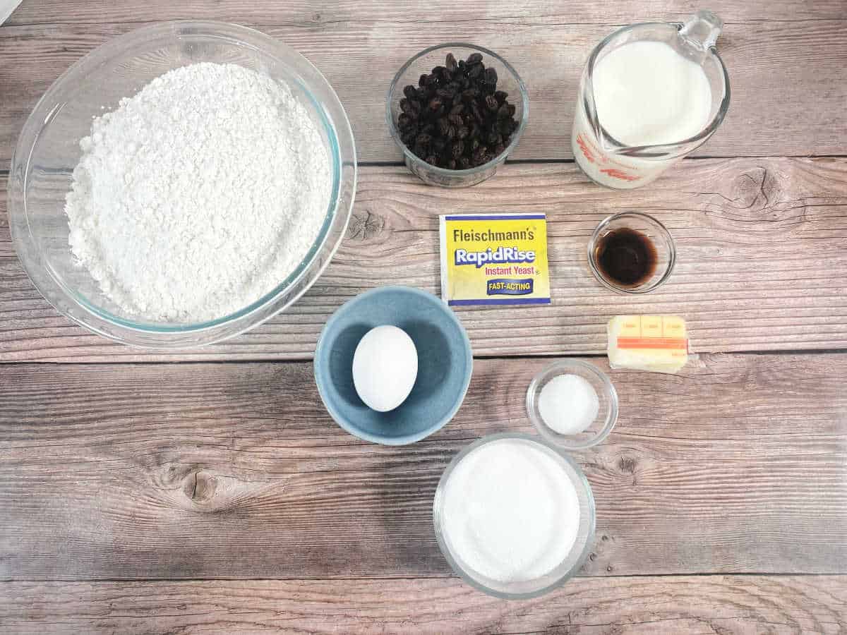 Ingredients for recipe sit in glass dishes on wooden background. 