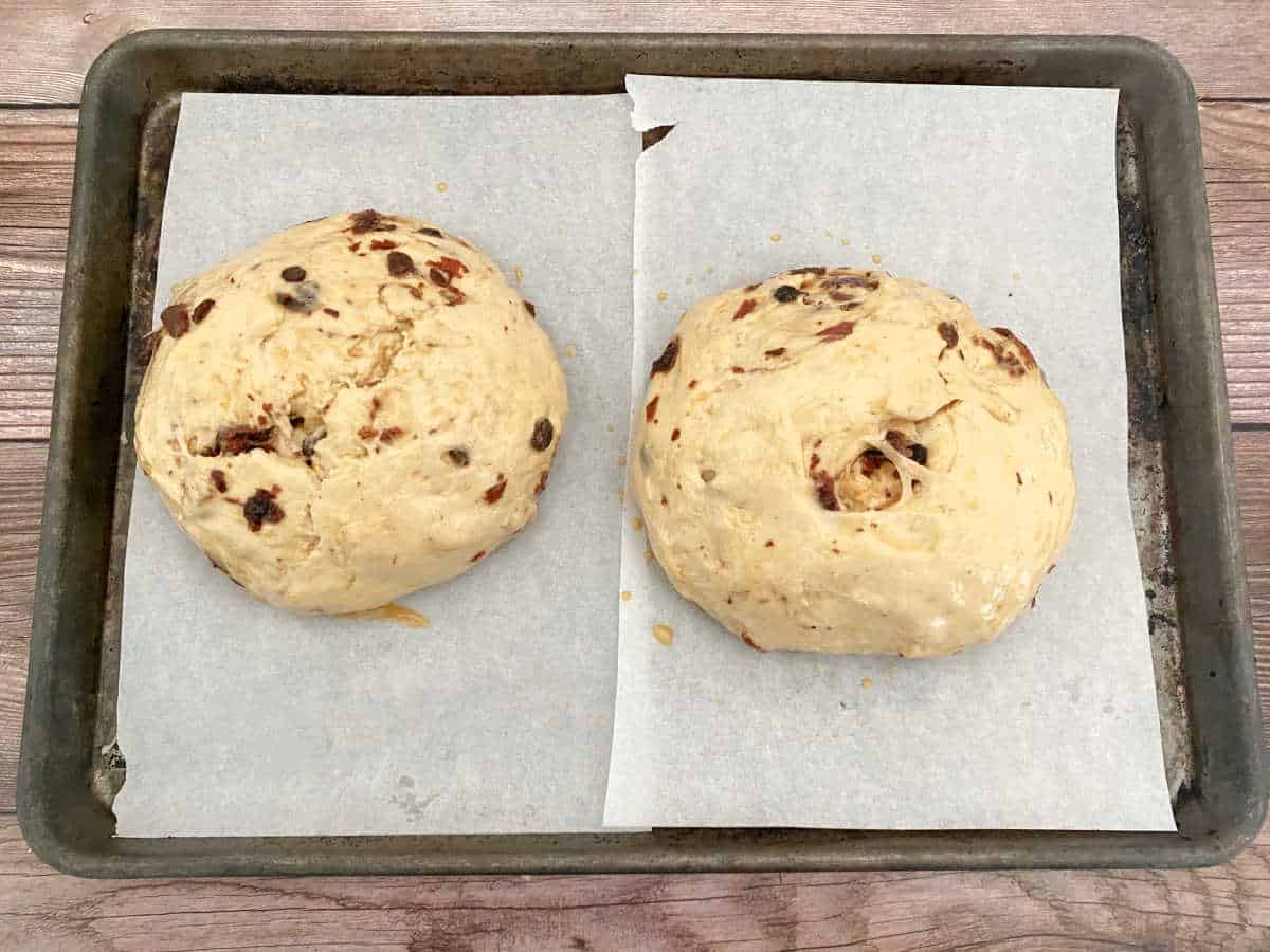 Process shot - divided dough sitting on parchment lined baking sheet. 