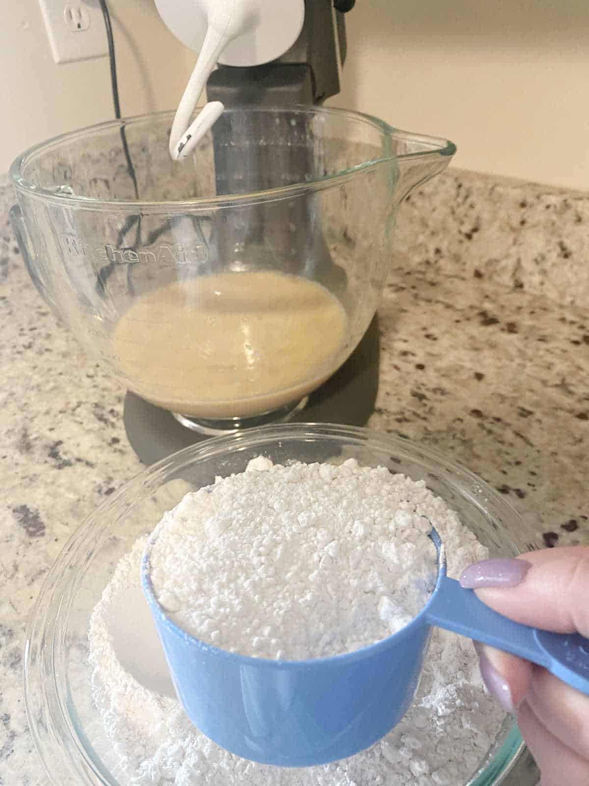 Process shot - wet ingredients in glass stand mixer bowl, flour measured and ready to be added to mixer.