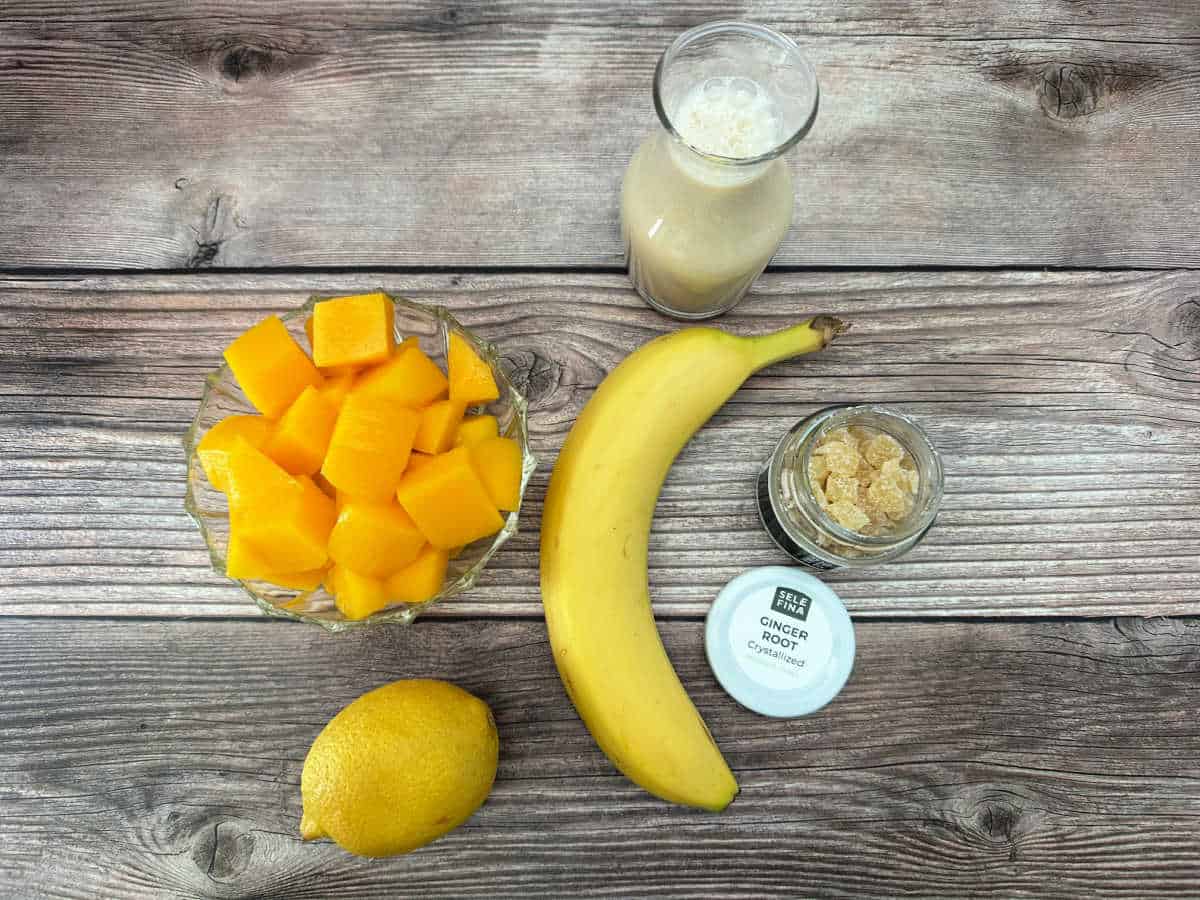 Ingredients for the smoothie sit on a wooden background. 