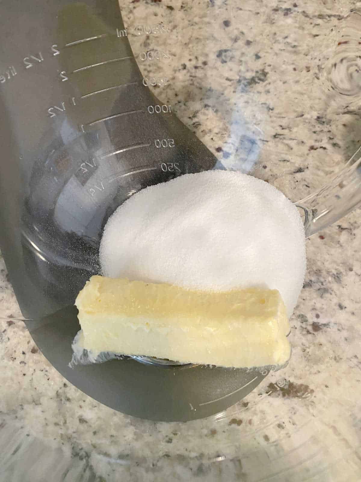 Process shot - butter and sugar in a glass bowl of a stand mixer. 