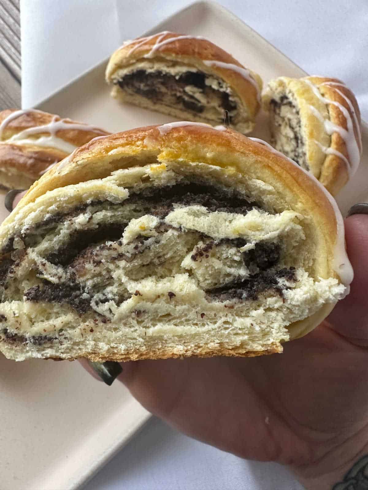 Close up image of poppy seed roll slice, showing the filling swirled around the bread. 