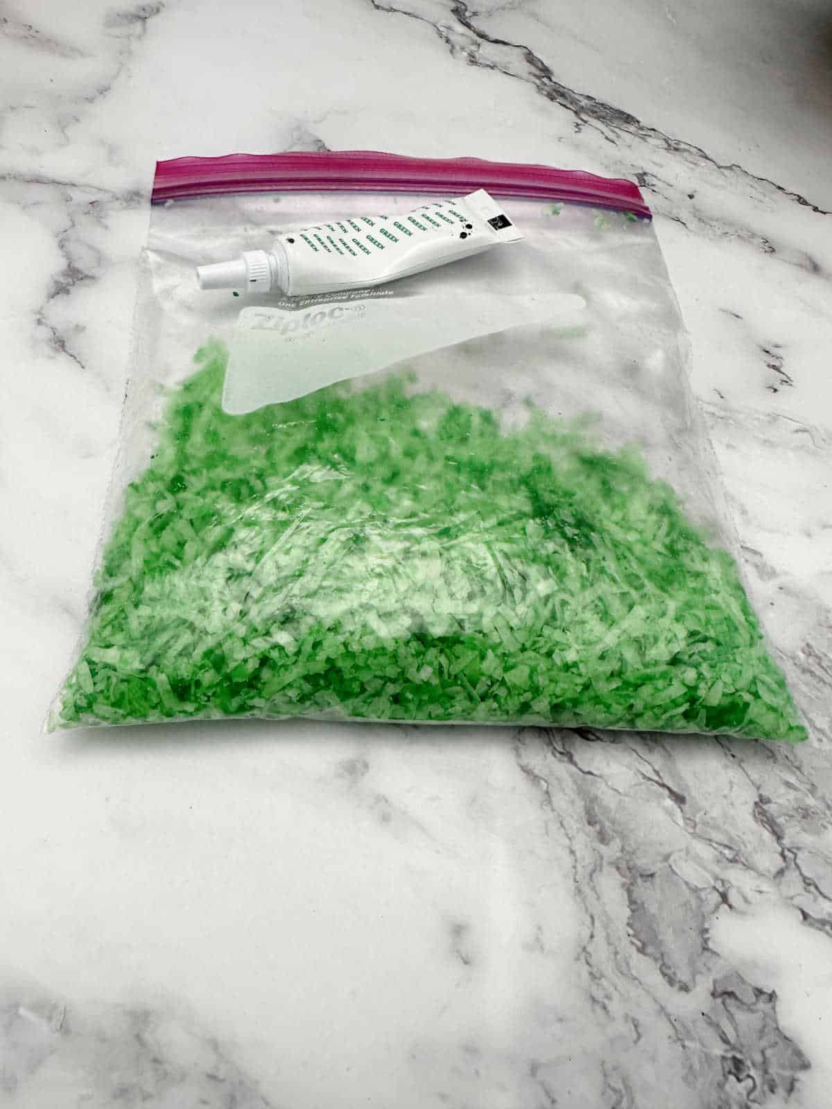 Process shot - ziplock bag of coconut flakes turned green from food coloring. 