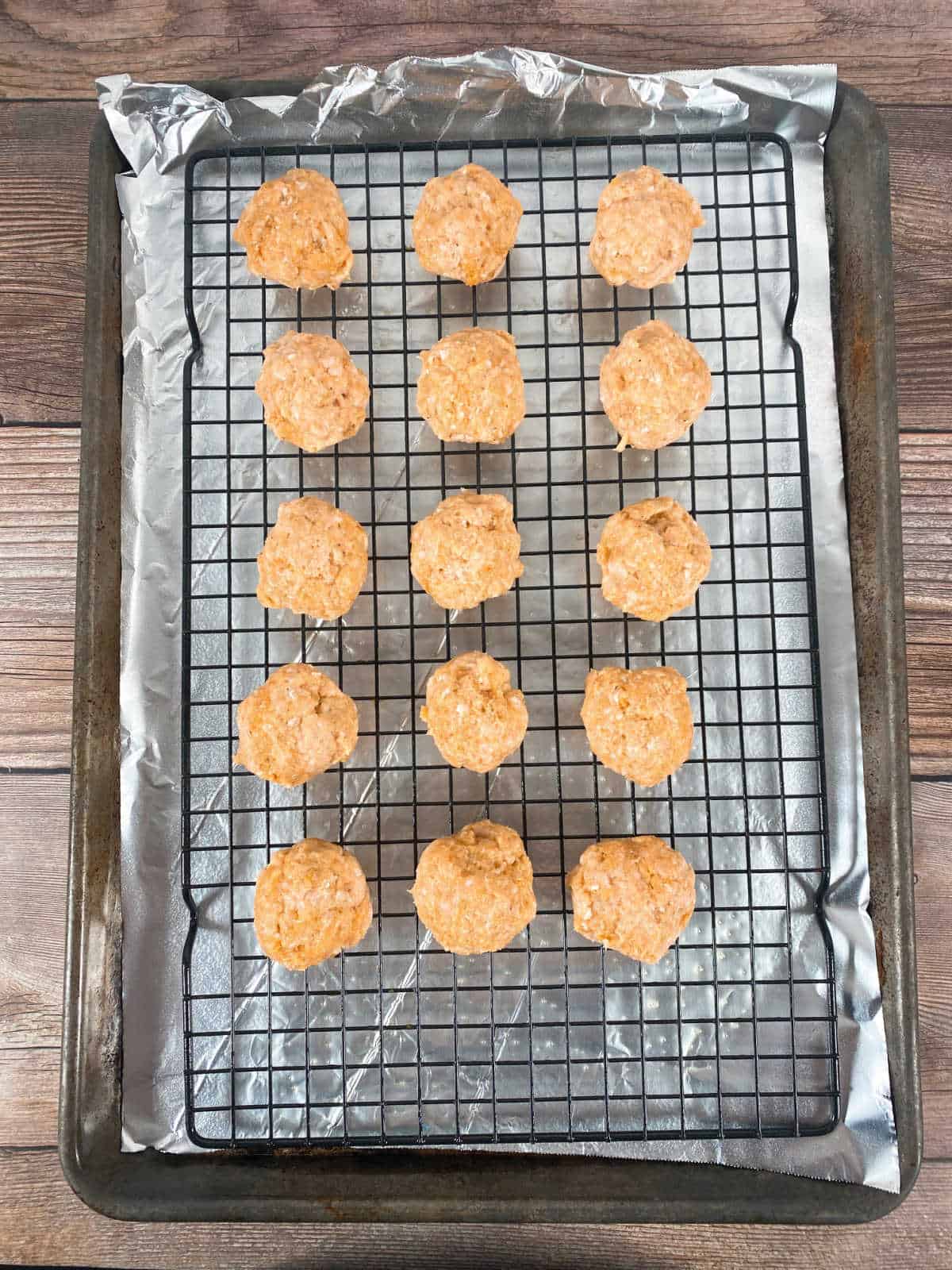 Process photo - meatballs on a wire rack ready to be baked. 