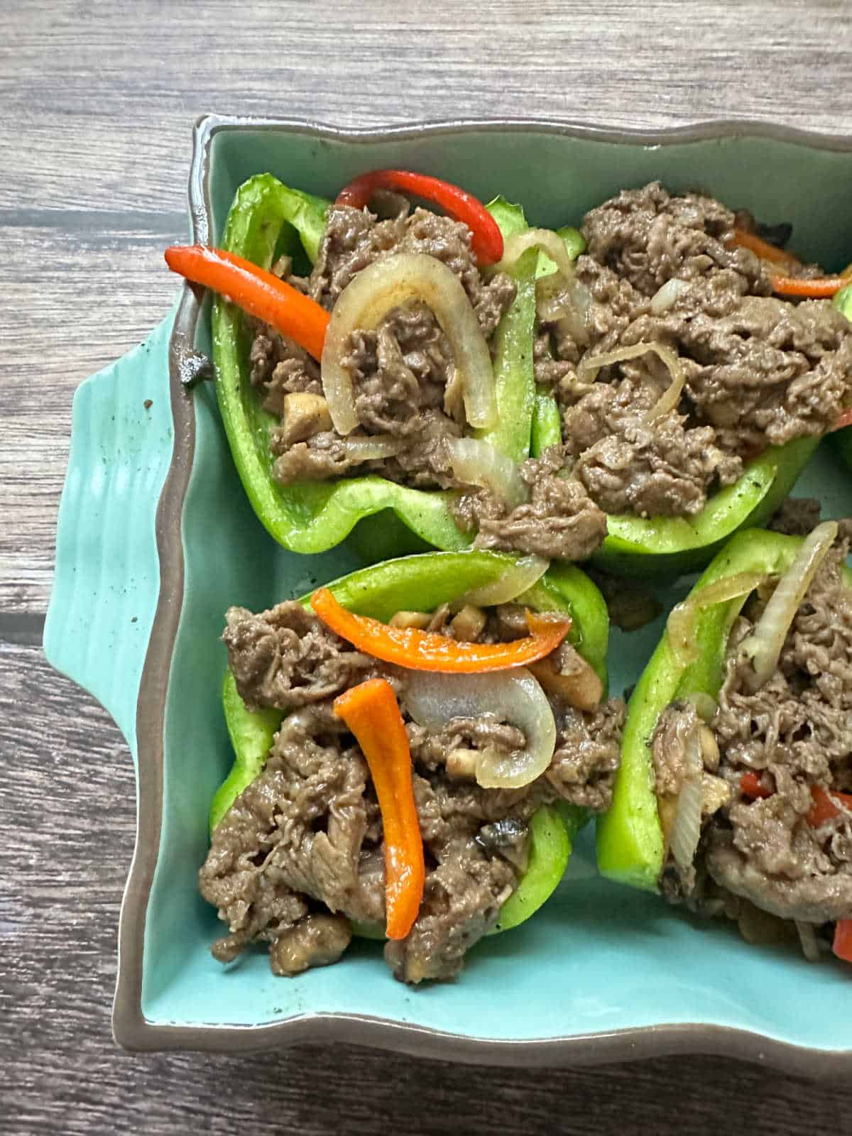 Process shot - overhead image of bell stuffed bell peppers in baking dish. 