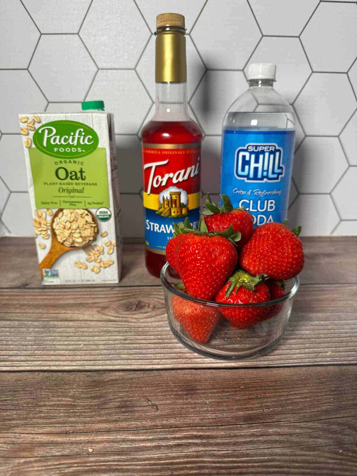 Ingredients for the drink sit on a wooden background. 