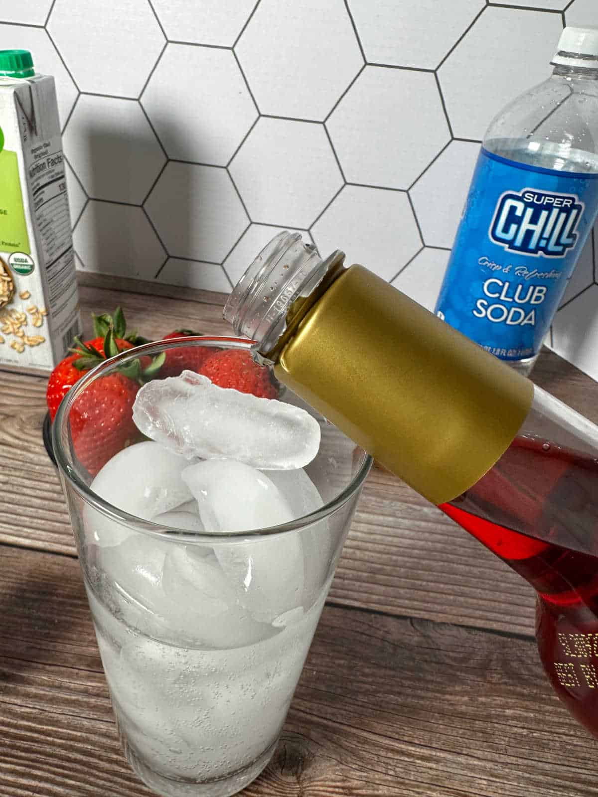 Strawberry syrup being poured into the glass. 