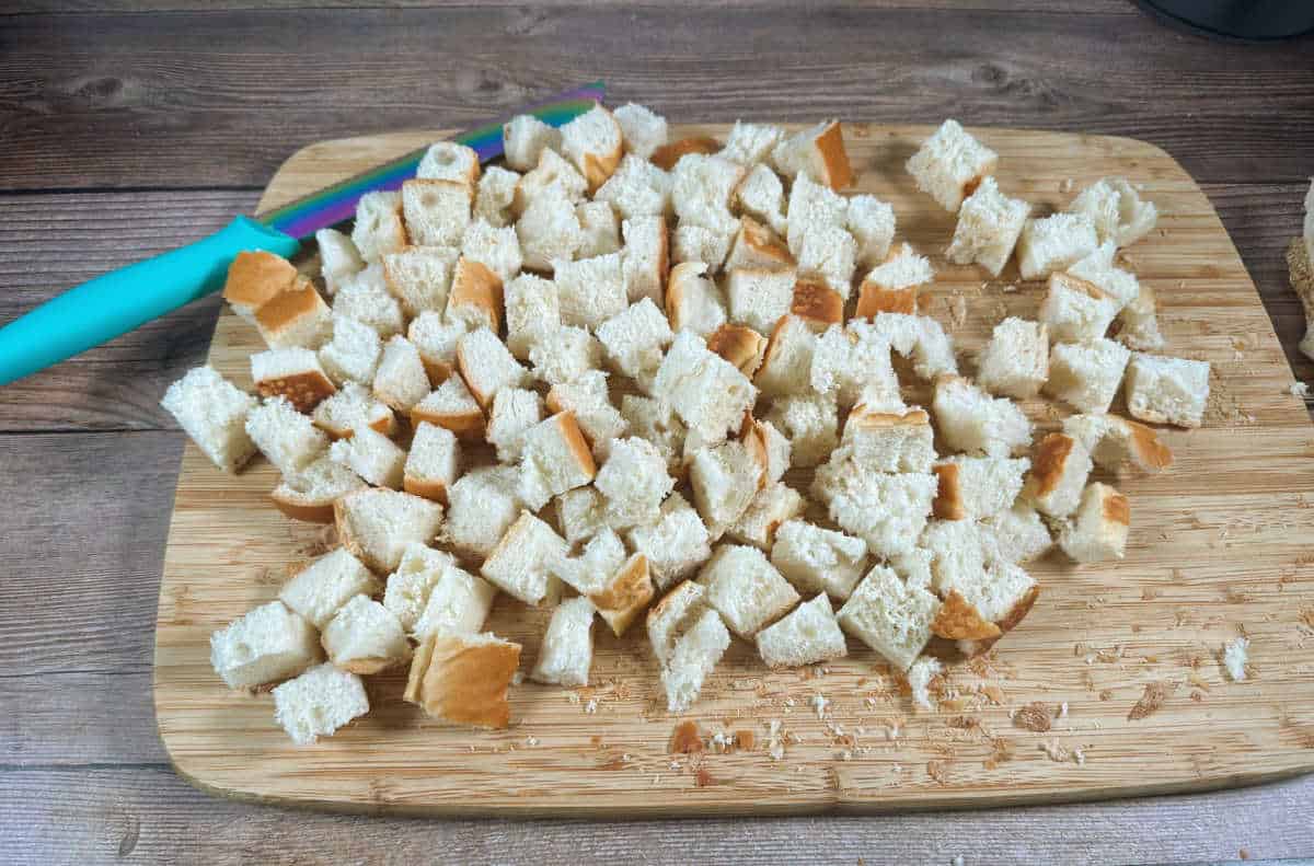 Process photo: cutting board full of bread cut into cubes.