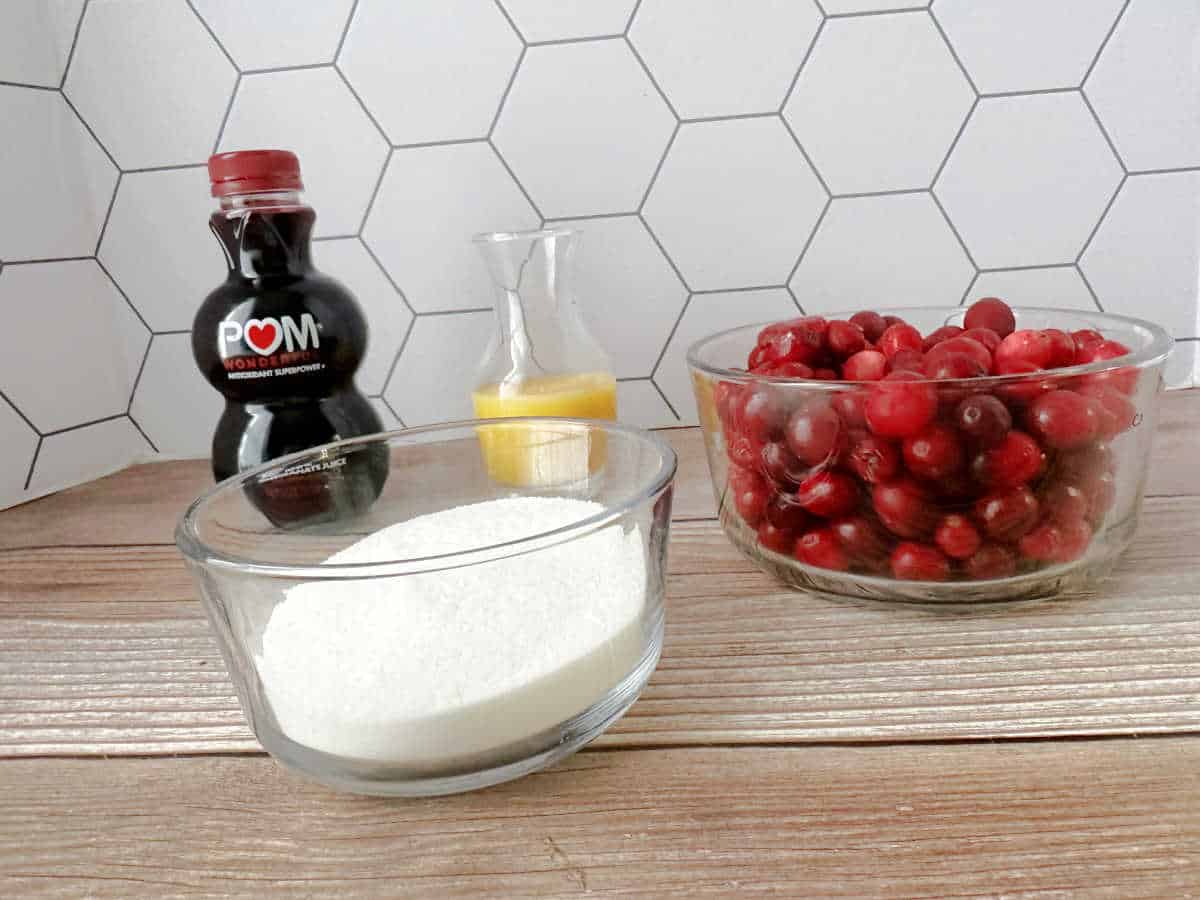 Ingredients for cranberry sauce on a wooden background. 