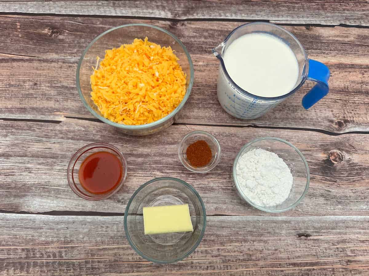 Process photo - ingredients sit in glass bowls on a wooden background. 