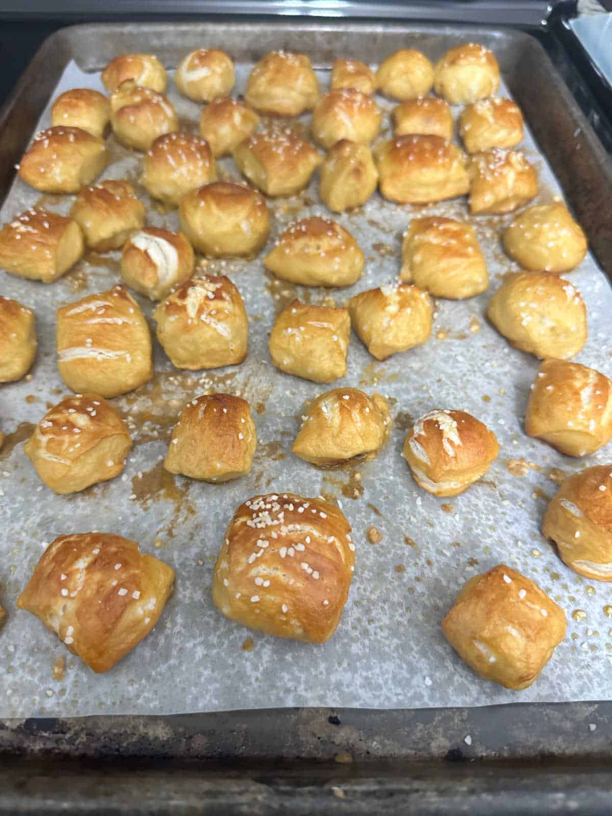 Overhead image of baked pretzel bites on a baking sheet. 